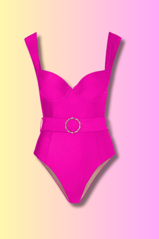 Un Maillot de Bain Fuchsia rose vif avec une ceinture et une boucle circulaire, présenté sur un fond bicolore rose et jaune par Sylvia CORRE.