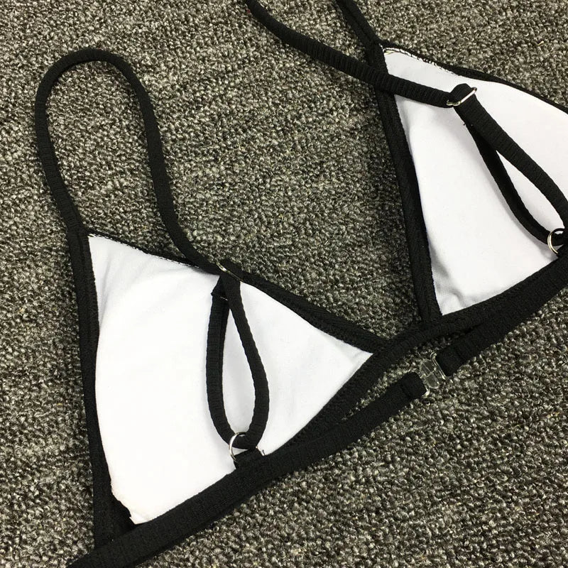 Un haut sexy Maillot de Bain 2 Pièces Noir Bikini 2024 blanc et noir au design triangulaire et à bretelles noires, disposé sur une surface grise texturée, conçu pour toutes les morphologies par BREEZE BEEZ.