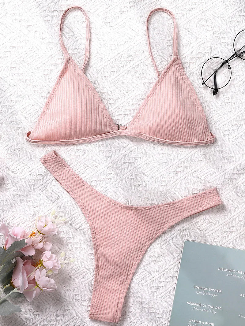 Un ensemble Maillot de Bain Femme 2 Pièces Bikini 2024 Sexy rose affiché sur un fond blanc texturé, accompagné d'une paire de lunettes, d'une fleur rose tendre et d'un livre ouvert, créant une ambiance très belle et féminine.