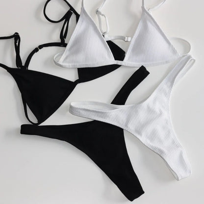 Un affichage monochrome de BREEZE BEEZ Maillot de Bain Femme 2 Pièces Bikini 2024 Maillots de bain sexy, comprenant un ensemble de bikini noir et un ensemble de bikini blanc à texture côtelée, soigneusement disposés sur une surface blanche pour une fête balnéaire.