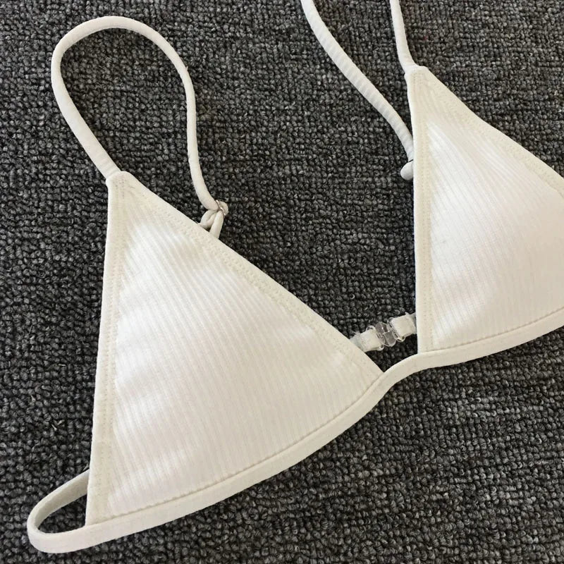 Un BREEZE BEEZ Maillot de Bain Femme 2 Pièces Bikini 2024 Sexy blanc allongé sur une surface grise texturée, prêt pour une fête au soleil.