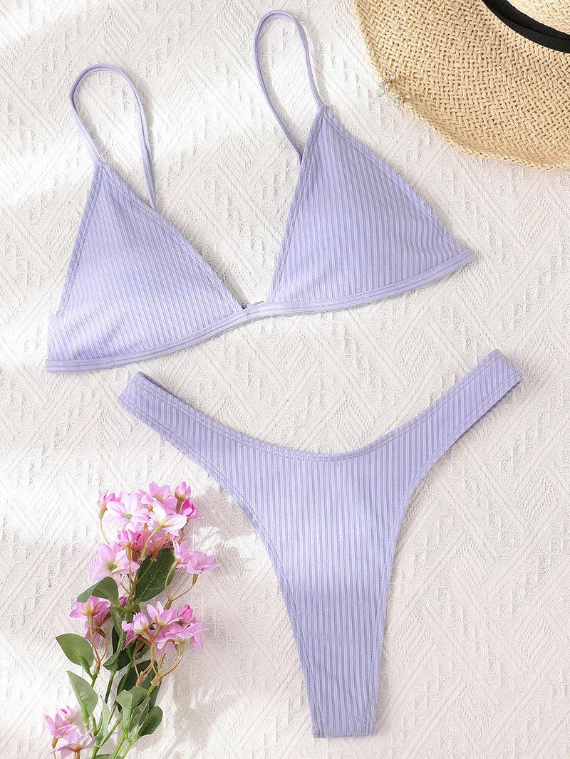 Maillot de Bain Femme 2 Pièces Bikini 2024 Ensemble bikini rayé sexy de BREEZE BEEZ, avec haut et bas assortis, affiché sur fond blanc texturé, accompagné d'un bouquet de fleurs roses et d'un chapeau de paille, évoquant une ambiance au soleil et décontractée