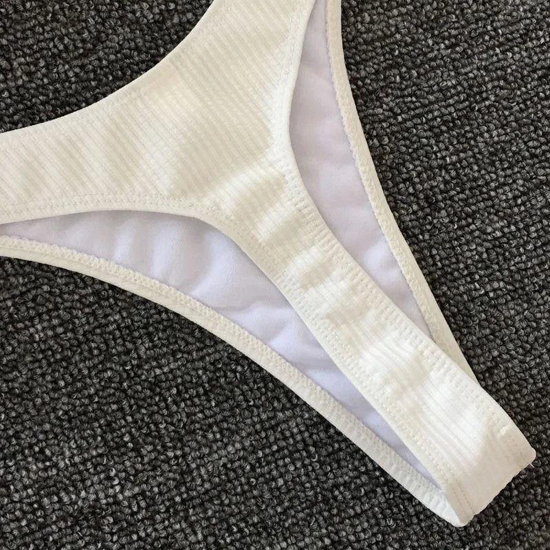 Une vue rapprochée d'un BREEZE BEEZ Maillot de Bain Femme 2 Pièces Bikini 2024 Sexy sur un fond gris texturé, parfait pour un cadre balnéaire.