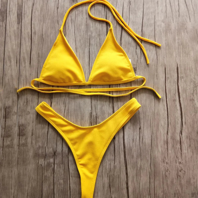 Un Maillot de Bain 2 Pièces Jaune Bikini 2024 Sexy de la marque BREEZE BEEZ est étendu à plat sur une surface en bois. Bienvenue dans notre boutique en ligne, l'oasis des femmes qui cherchent le parfait maillot de bain.