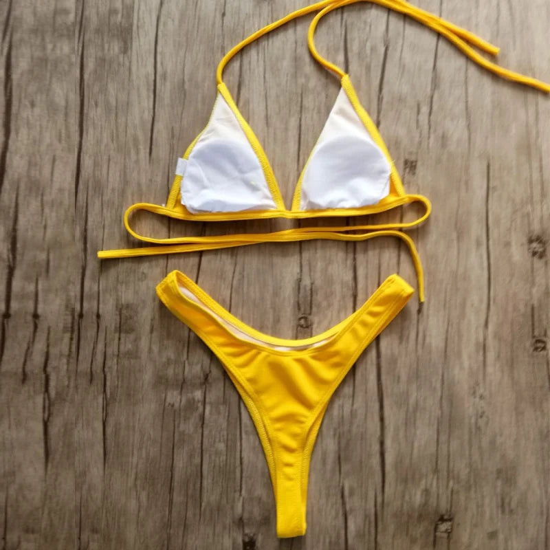 Bienvenue dans notre boutique en ligne, où un ensemble Maillot de Bain 2 Pièces Jaune Bikini 2024 Sexy est soigneusement disposé sur une surface en bois, conçue pour toutes les morphologies. Marque BREEZE BEEZ