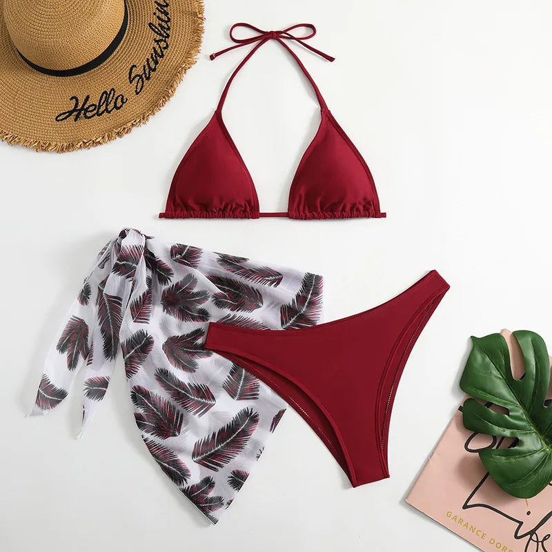 Une collection à plat d'essentiels d'été comprenant un haut de bikini BREEZE BEEZ rouge et un Maillot de Bain Femme 3 Pièces à motifs blancs et gris | Un bas de bikini Ensemble haut & Bas, un chapeau de paille avec la phrase "hello sunshine" autour du bord, une paire de vert confortable.