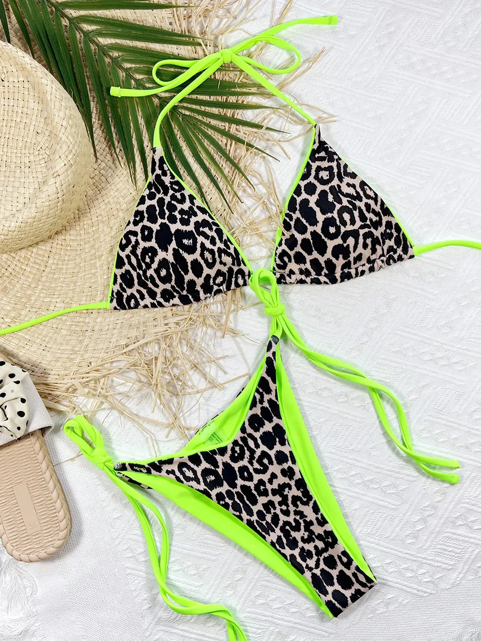 Un bikini 2 pièces maillot de bain vert imprimé léopard vibrant avec des accents vert fluo disposés sur une surface blanche texturée, accompagné d'accessoires d'été dont un chapeau de paille et des sandales, mettant en valeur un look de plage chic et audacieux de BREEZE BEEZ.