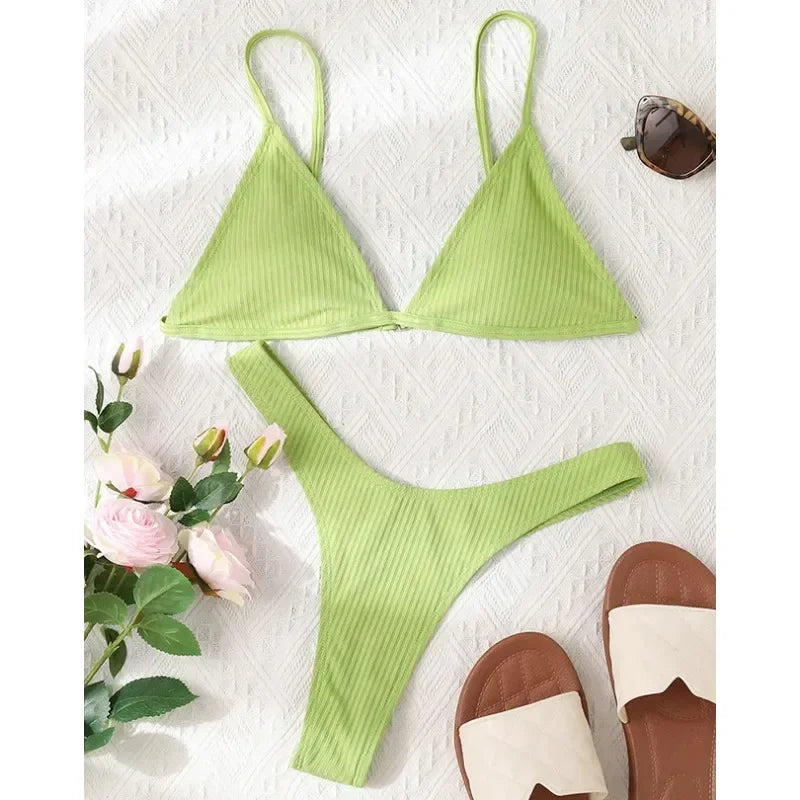 Une présentation à plat d'essentiels d'été comprenant un Maillot de Bain 2 Pièces Bleu Bikini 2024 Sexy de BREEZE BEEZ, une paire de sandales marron, des lunettes de soleil et un bouquet.