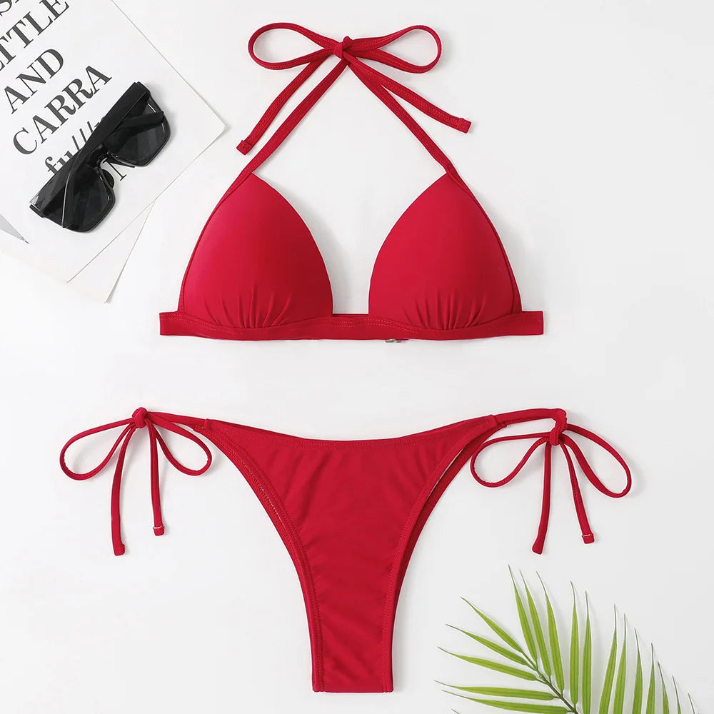 Ensemble maillot de bain avec détails à nouer en Rouge Femme de BREEZE BEEZ, affiché sur un fond uni, accessoirisé de lunettes de soleil et d'une feuille tropicale pour un look estival.