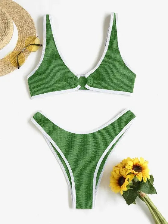 Une mise en scène à plat d'un très beau Maillot de Bain Vert 2 Pièces zippées de BREEZE BEEZ avec une bordure blanche contrastante, accompagné d'un chapeau de paille et des lunettes de soleil.