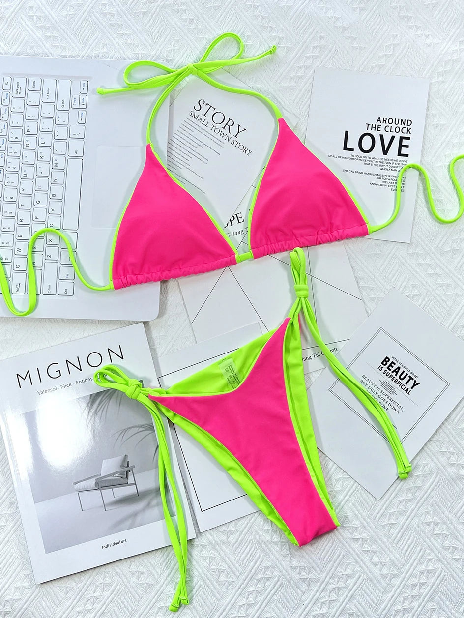 Bikini Maillot de Bain Femme 2 Pièces rose vif avec bordure vert fluo affiché sur un fond chic de livres de mode monochromes et un clavier élégant, symbolisant un mélange de travail, de style et de loisirs BREEZE BEEZ.