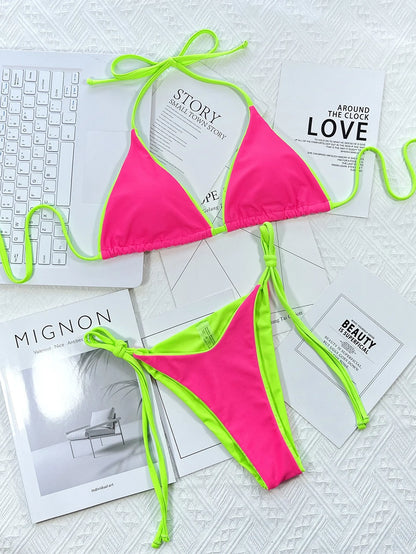 Bikini Maillot de Bain Femme 2 Pièces rose vif avec bordure vert fluo affiché sur un fond chic de livres de mode monochromes et un clavier élégant, symbolisant un mélange de travail, de style et de loisirs BREEZE BEEZ.