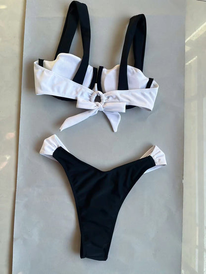 Bienvenue dans notre boutique en ligne où vous découvrez un maillot de bain bandeau 2 pièces noir BREEZE BEEZ avec un détail de nœud, posé à plat sur une surface claire. Nos maillots mettent