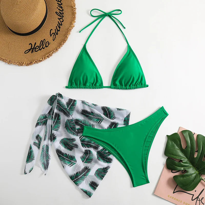 BREEZE BEEZ Maillot de Bain Femme 3 Pièces | Ensemble haut & Bas en très beau vert avec des motifs de feuilles tropicales, accompagné d'un chapeau de paille avec le message "hello sunshine" et d'un décor de feuilles de monstera, suggérant une ambiance de plage estivale.