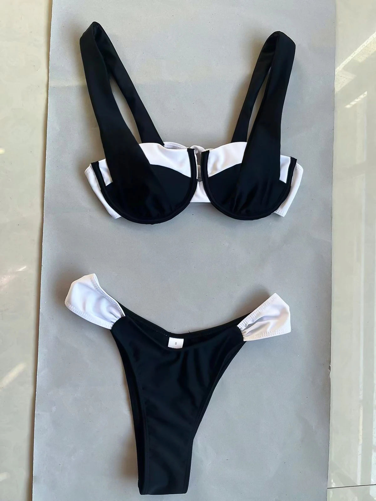 Bienvenue dans notre boutique en ligne, où vous trouverez un maillot de bain bandeau 2 pièces noir de la marque Breeze Beez, posé à plat.