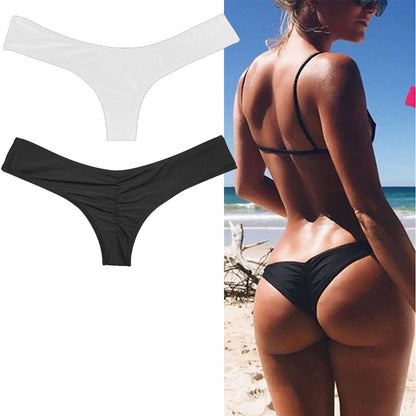 Bienvenue dans notre boutique en ligne, une oasis des femmes qui cherchent le bas de maillot de bain parfait ! Une personne debout sur une plage, montrant une vue de dos portant le Bas de Maillot de Bain Noir Femme de BREEZE BEEZ.