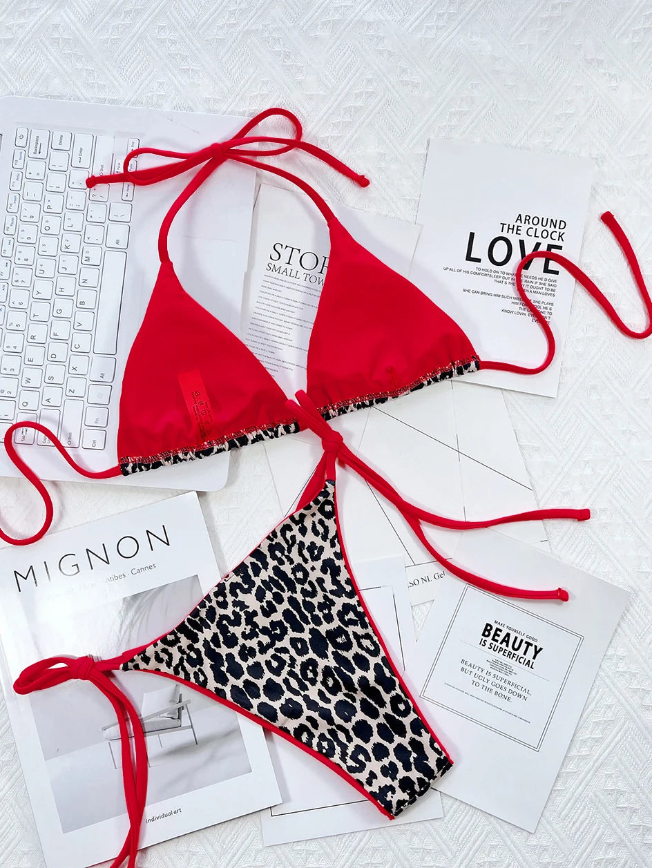 Une pose plate élégante comprenant un très beau bikini Maillot de Bain Rouge Femme 2 Pièces avec des ficelles à nouer, un bas imprimé léopard et un assortiment de découpes de magazines de mode, soigneusement disposés avec un clavier blanc en toile de fond par BREEZE BEEZ.