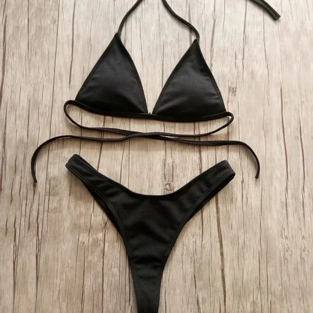 Une Maillot de Bain 2 Pièces Noir Bikini 2024 Sexy BREEZE BEEZ posé à plat sur une surface en bois, conçu pour toutes les morphologies.