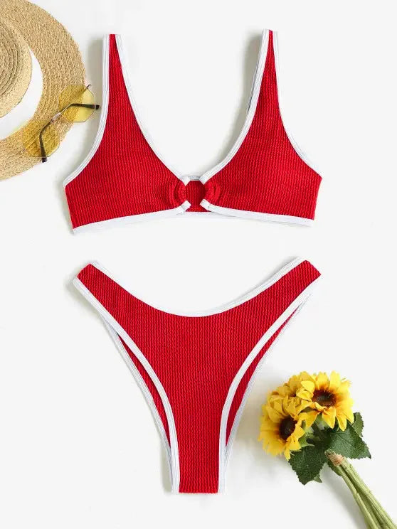 Une photo à plat d'un Maillot de Bain Femme 2 Pièces rouge de BREEZE BEEZ avec un motif à nouer sur le devant, associé à un chapeau de paille, des lunettes de soleil et un bouquet de fleurs jaunes, suggérant une tenue estivale à la plage.