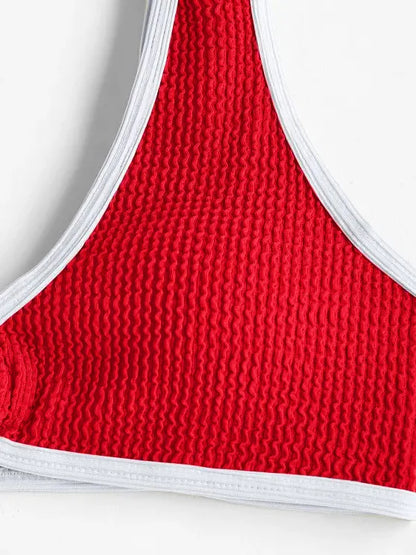 Gros plan d'un tricot rouge avec une texture côtelée et une bordure blanche, au soleil, probablement un détail d'un Maillot de Bain Femme 2 Pièces tel qu'un maillot de bain ou un vêtement de BREEZE BEEZ.