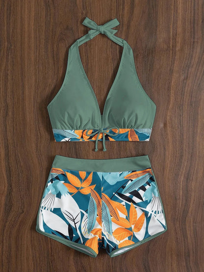 Un haut de bikini sexy Maillot de Bain Boxer 2 pièces tendance de couleur unie associé à un short taille haute à imprimé tropical vibrant, affiché sur un fond en bois, parfait pour se prélasser au soleil. (Marque : BREEZE BEEZ)