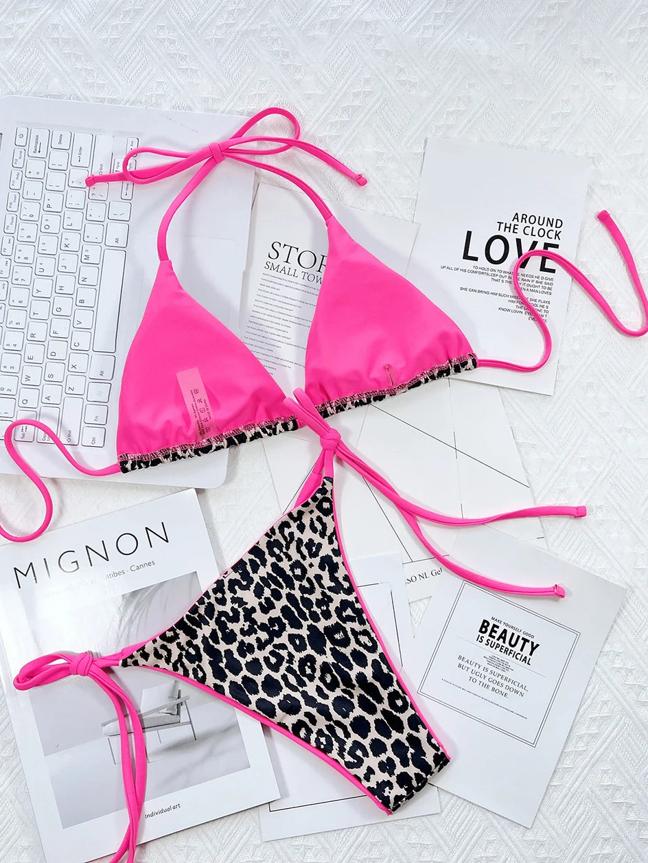 Un haut de bikini BREEZE BEEZ rose vif associé à un bas de bikini Maillot de Bain Femme 2 Pièces à imprimé léopard, élégamment disposés sur une série de magazines de mode monochromes et un clavier sur une surface blanche texturée, parfait pour une fête au soleil.