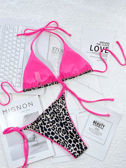 Un haut de bikini BREEZE BEEZ rose vif associé à un bas de bikini Maillot de Bain Femme 2 Pièces à imprimé léopard, élégamment disposés sur une série de magazines de mode monochromes et un clavier sur une surface blanche texturée, parfait pour une fête au soleil.