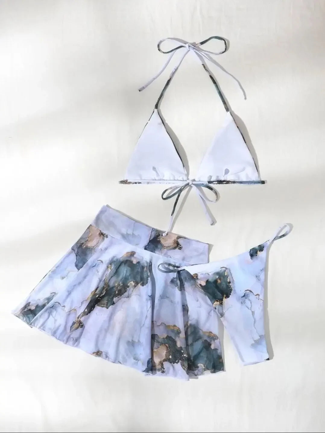 Une tenue d'été deux pièces élégante comprenant un haut à nouer à col licou et un Maillot de Bain Bleu Femme taille haute assorti | Jupette 2 Pièces avec un imprimé pastel abstrait de BREEZEBEEZ.