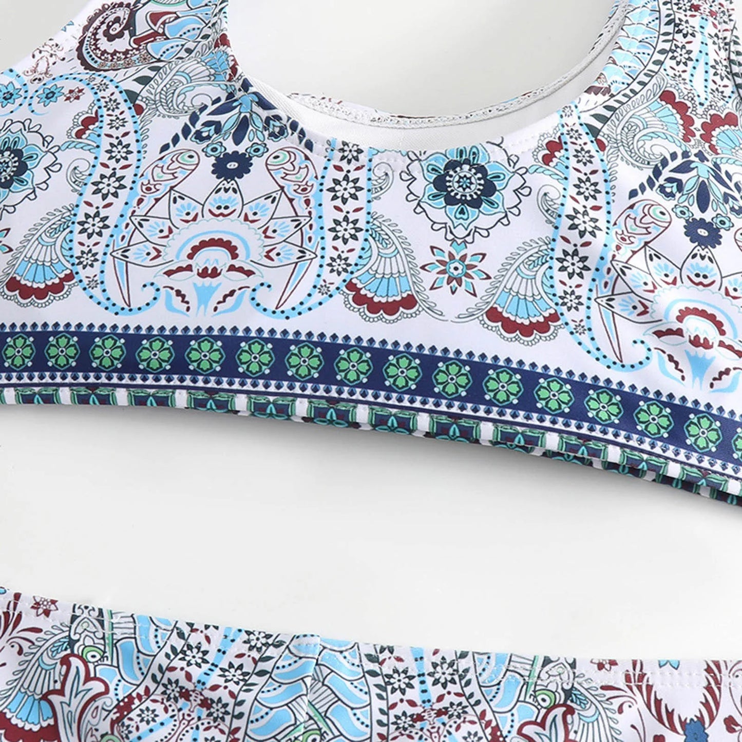 Une vue rapprochée du Maillot de Bain Bleu 2 Pièces | Brésilienne de BREEZE BEEZ, avec des motifs cachemire et floraux complexes et colorés avec un accent sur la bordure détaillée de l'encolure, vous souhaite la bienvenue dans notre boutique en ligne.