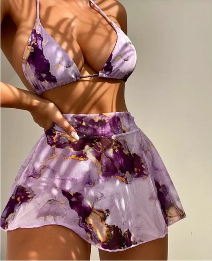 Femme en Maillot de Bain Jupette | Mauve 3 pièces Sexy BREEZEBEEZ, composé d'un haut de bikini à motifs et d'une jupette pour femme assortie, posant sous le