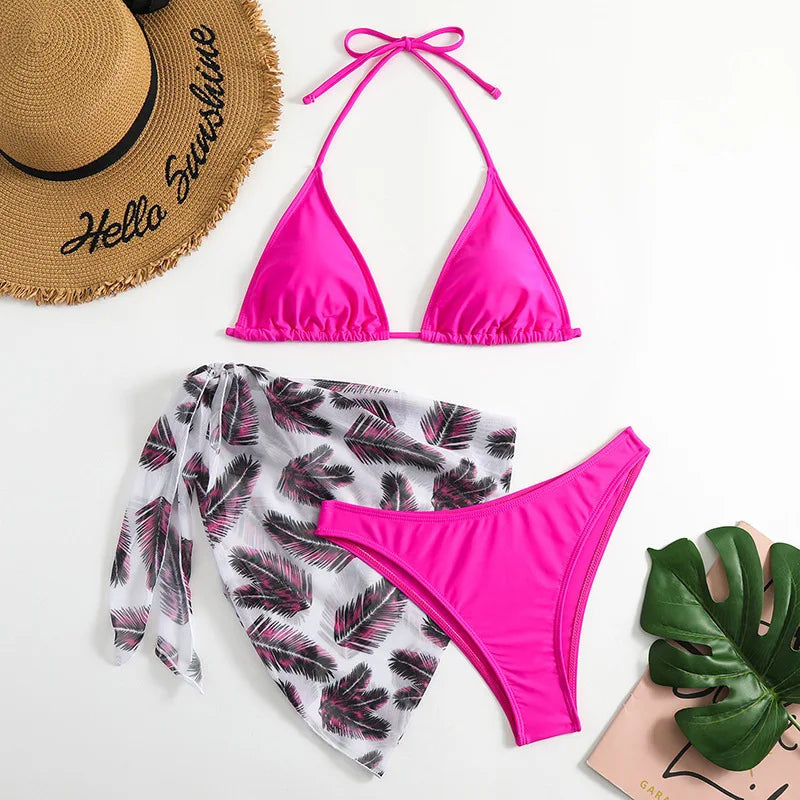 Maillot de Bain Femme 3 Pièces BREEZE BEEZ rose vif avec une couverture à motifs de feuilles tropicales, un chapeau de paille tendance et une décoration de feuilles de monstera, le tout prêt pour une très belle escapade estivale.